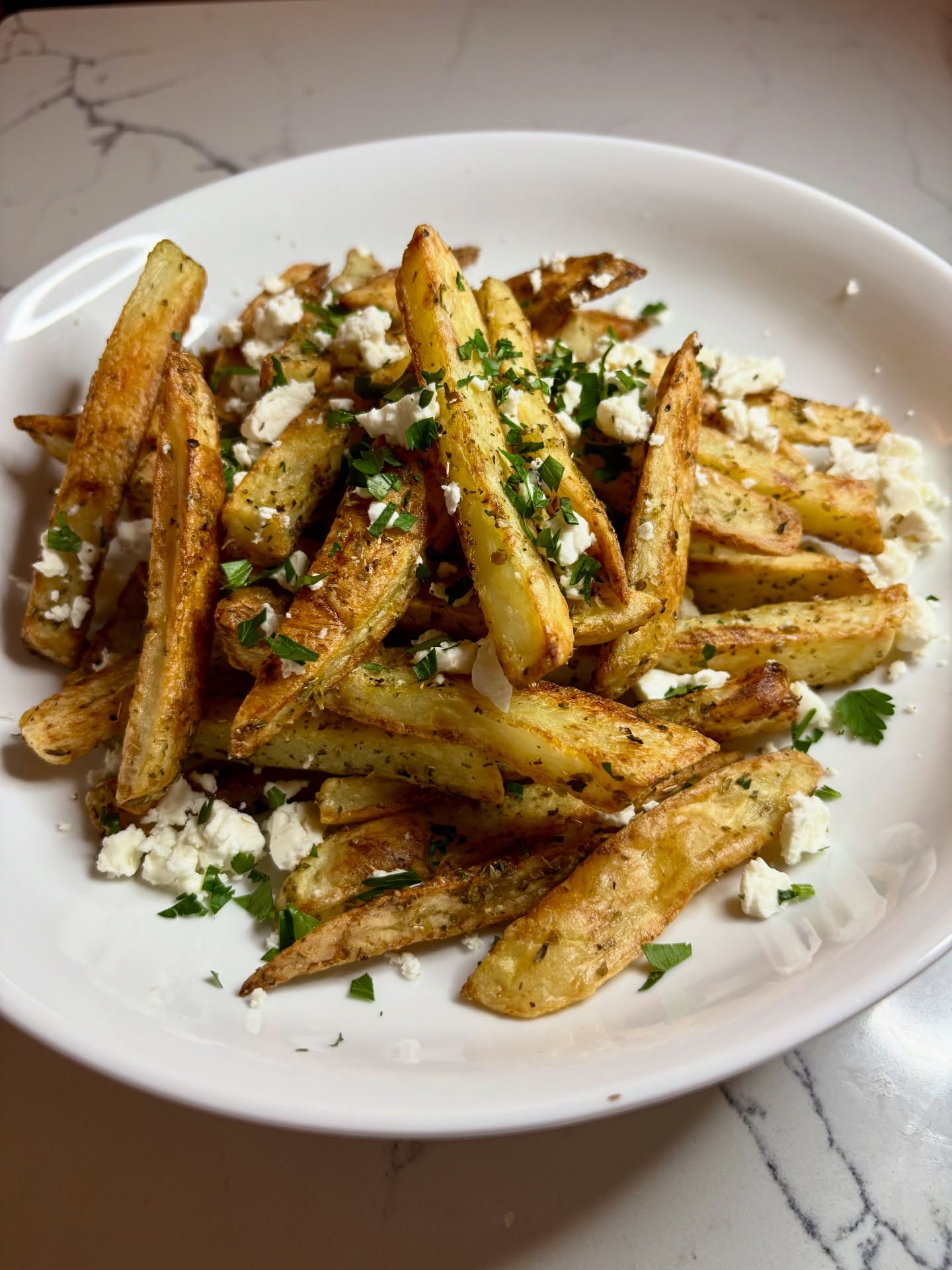 I bought far too many Maris Piper for Christmas so needed to use them up… seem to have had every type of potato going over the last couple of weeks so decided to make Greek fries. Cut the potatoes into chips and soaked them, then drained and dried before mixing with oregano, olive oil and salt. Cooked them in the oven for 40 mins turning halfway through and garnished them with crumbled feta and parsley. Served with griddled chicken souvlaki, salad and homemade tzatziki. Boys loved it!
#greekfood #fries #bristolfoodie