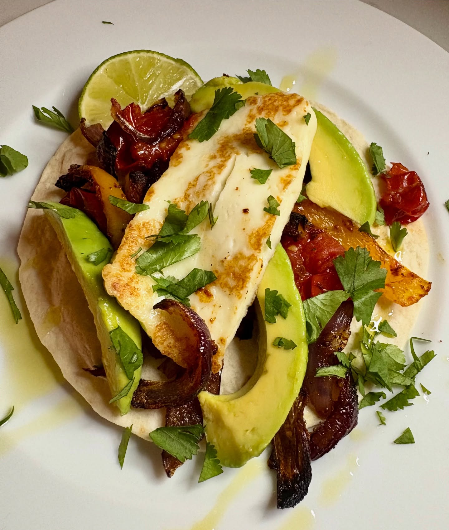 Looked in the fridge tonight and there was not a lot there! So roasted red onion, yellow pepper and tomatoes in cumin, paprika and oregano and served them on soft tortillas. Topped with avocado (that had been sliced and drizzled with lime juice and olive oil), pan fried halloumi and coriander. Was actually really good but now the fridge is officially bare!
#tortillas #tacos #halloumi