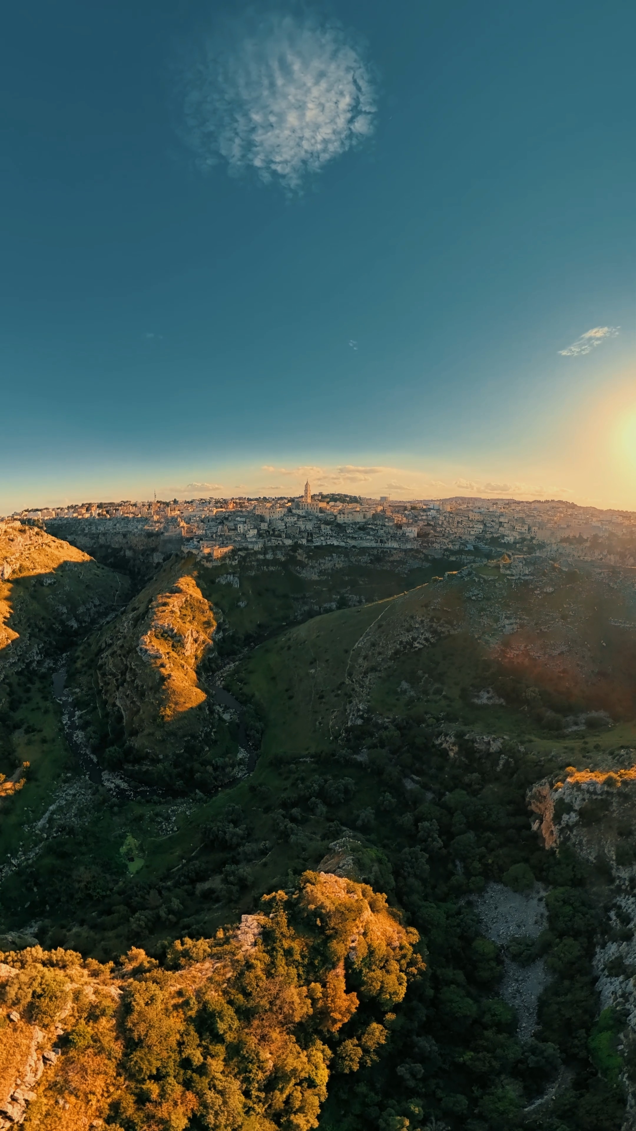 Matera al tramonto ha qualcosa che non si spiega, si guarda e basta.
La luce scivola sulla Gravina di Matera, il tempo sembra rallentare e ogni dettaglio racconta una storia antica, silenziosa, viva.
Dall’alto, tutto diventa ancora più intenso: pietra, cielo e tramonto si fondono in un’unica emozione.
#matera #gravinadimatera #tramonto #droneview #stoploop #djı