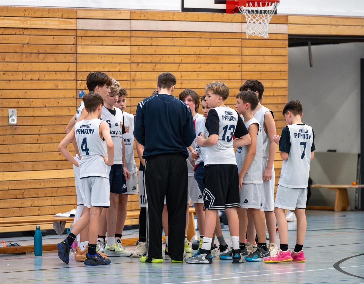 Saisonbericht mu14-2/3 Letzten Herbst startete eine große Trainingsgruppe die sowohl Landesliga als auch Bezirksliga spielte in eine aufregende Saison. Das Team bestand aus erfahrenen u14ern aber auch engagierten u13ern und u12ern, was für alle ganz neu war.
Das führte unter anderem dazu, dass wir oftmals gegen ältere und größere Gegner spielen sollten.
Gerade am Anfang fiel es uns recht schwer, gegen körperliche Teams dagegen zu halten und unsere Stärken auszuspielen. Wir bekamen es aber über das Jahr hinweg immer besser hin, unsere Stärke von Tempo und intensiver Defense auszuspielen. Das brachte uns in der Bezirksliga über die ganze Saison hinweg viele tolle Spiele mit einigen Siegen.
In der Landesliga fiel uns gerade in der Hinrunde das schnelle Spiel sehr schwer, in der Rückrunde haben wir das Ruder rumgedreht und selbst ein paar Teams überrannt. Vor allem sind wir aber als Teammates gewachsen und trotz einiger Rückschläge immer ein tolles Team gewesen.
Durch unseren Teamgeist und Einsatz erkämpften wir uns in der Landesliga einen 7. Platz und in der Bezirksliga Platz 1. Diese Saison voller Höhen und Tiefen ist nun vorbei und einige Jungs trifft man bald in den U14 Oberligen und Landesligen, andere schon in der u16!