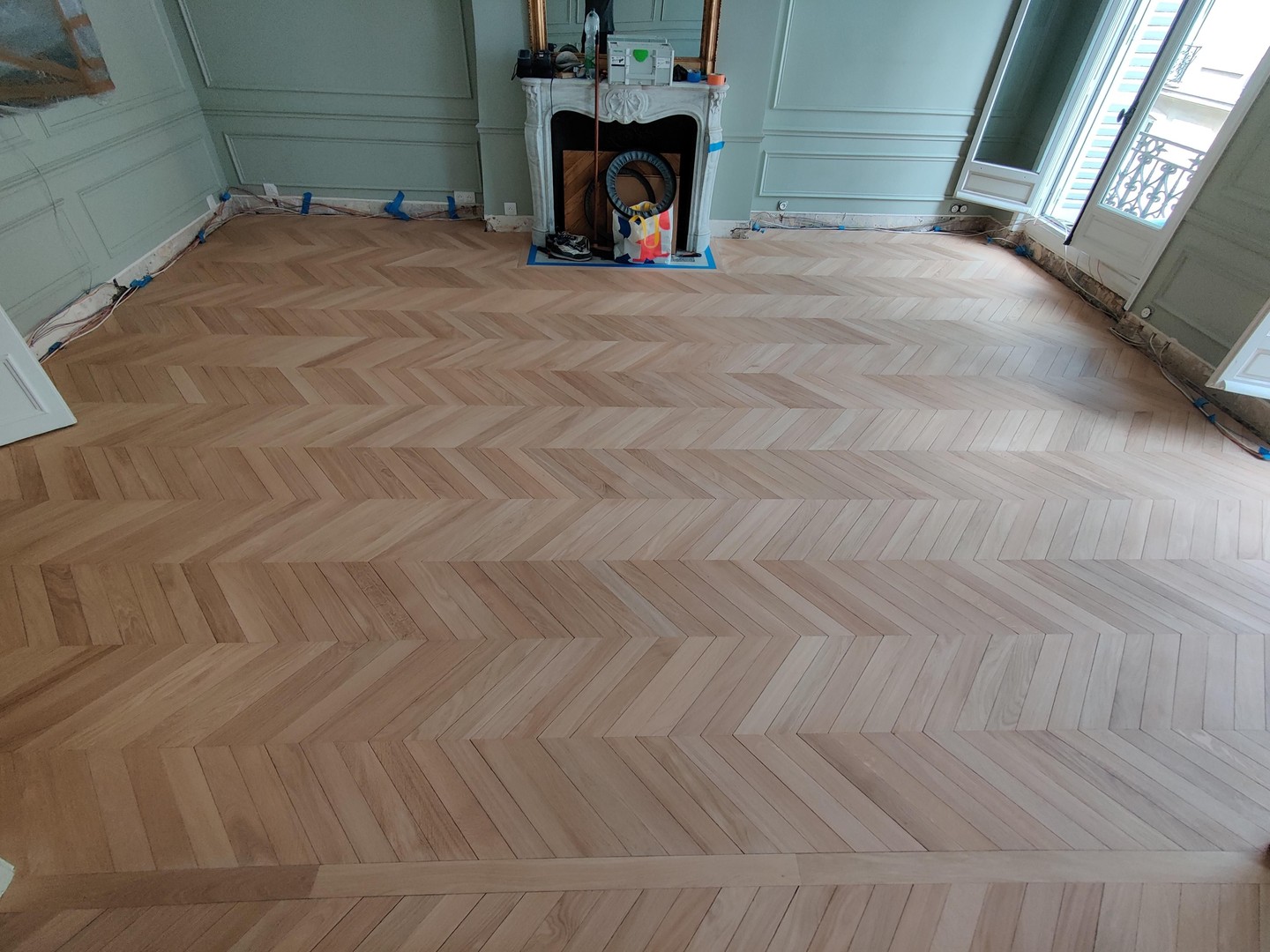 Sur la forme sèche réalisée précédemment, place à la pose du parquet.
Nous avons choisi un parquet massif, fabriqué en France avec des chênes issu des forets de bourgogne.Nous l'avons vieilli artificiellement, afin de s'accorder avec le caractère du lieu.
Le parquet a été fabriqué sur-mesure en fonction des dimensions de la pièce afin d'obtenir uniquement des travées complètes, et de s'aligner parfaitement avec les cloisons et la cheminée. Cheminée qui a bien sur reçu un encadrement taillé sur mesure.
Il a ensuite été posé avec des écarts volontaires entre certaines lames. Ce détail, qui peut surprendre au premier regard, reproduit le jeu naturel que l'on retrouve sur les parquets anciens, dû aux variations d'hygrométrie au fil des décennies.
Cette pose demande plus de temps et d'attention qu'une pose classique : chaque lame est positionnée en tenant compte du rendu d'ensemble. Cette technique permet un aspect ancien qui s'accord avec l'esprit Haussmannien de l'appartement.
Suite du chantier dans le prochain post, avec la mise en teinte et la finition.
#Parquet #SurMesure #ArchitectureIntérieure #ArtisanatFrançais #DesignIntérieur